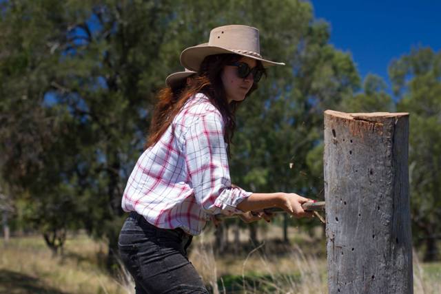 Girl learning to wire a fence