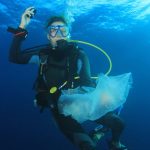 A volunteer helps to remove plastic from the sea in Portugal