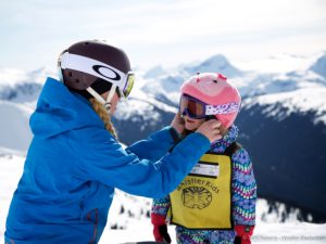 Whistler Kid having helmet fitted by instructor