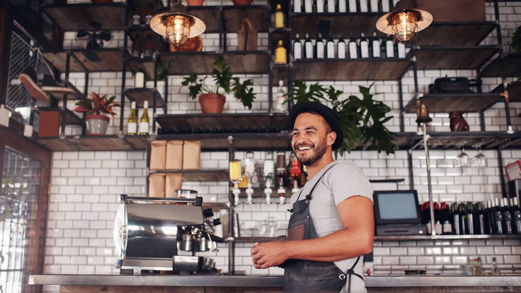 A worker laughs happily in his bar