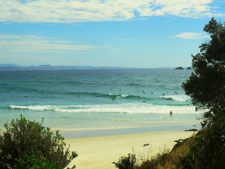 Beach scene of surfers riding the waves in the iconic town of Byron Bay 