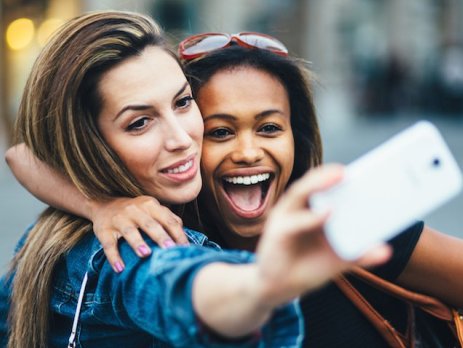 Two girls posing for a selfie shot in a city 