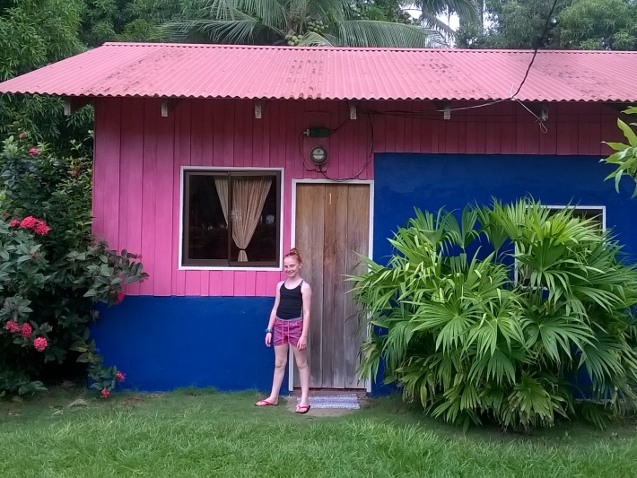 Girl standing in front of Costa Rica pink volunteer hut