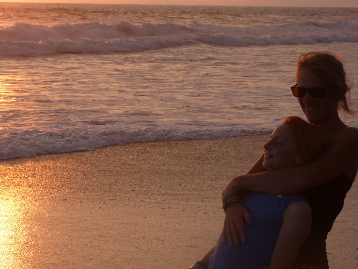 Mother and daughter on beach laughing and smiling in Costa Rica sunset