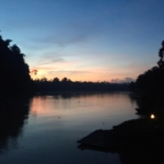 The sun sets over the river in Borneo