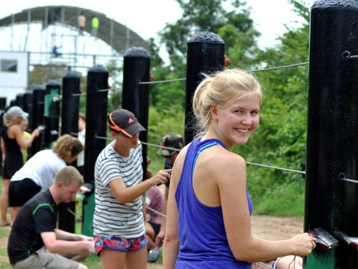 Teenagers help with painting an enclosure in Thailand on a volunteering for under 18s project