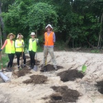 Volunteers pose next to their freshly planted plants