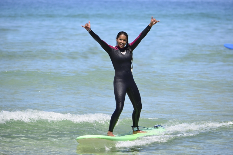 Girl standing on a surf board in he ocean 