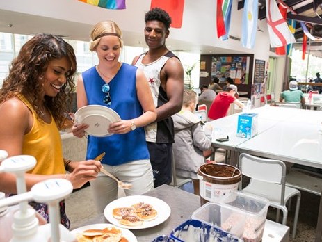 Travellers enjoying pancakes in the communal dining area at Sydney's Railway Square YHA hostel in central Sydney