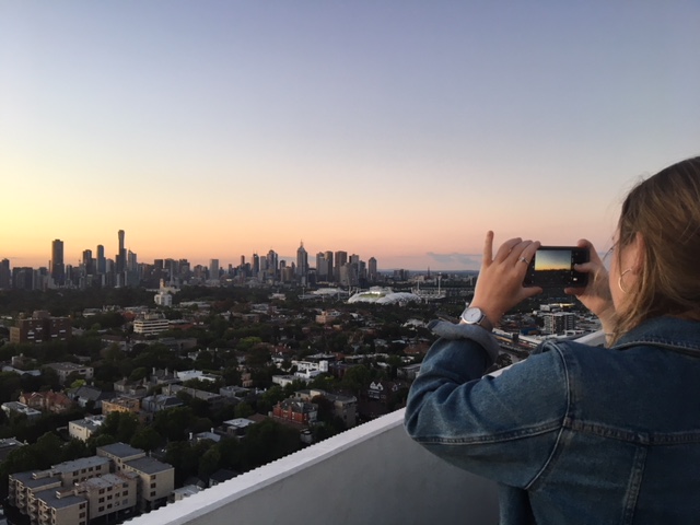 Girl taking a photo of the Melbourne Skyline 