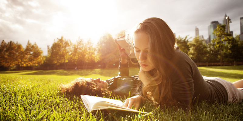 Two Young Women Readin In Park At Sunset